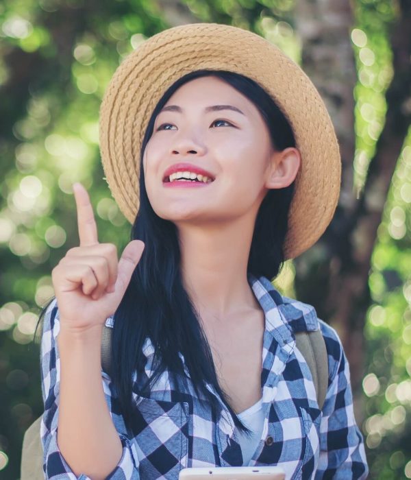 young-woman-traveler-using-the-phone-in-the-forest-6HKLGH3.jpg